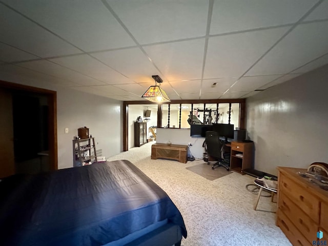 carpeted bedroom featuring a drop ceiling