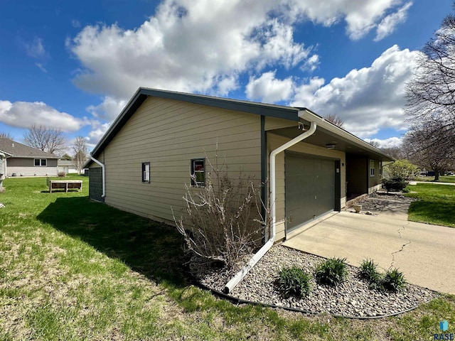 view of home's exterior featuring a garage, a yard, and concrete driveway