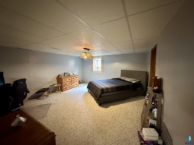 bedroom with a drop ceiling and carpet