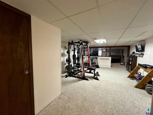 workout room featuring carpet floors and a drop ceiling