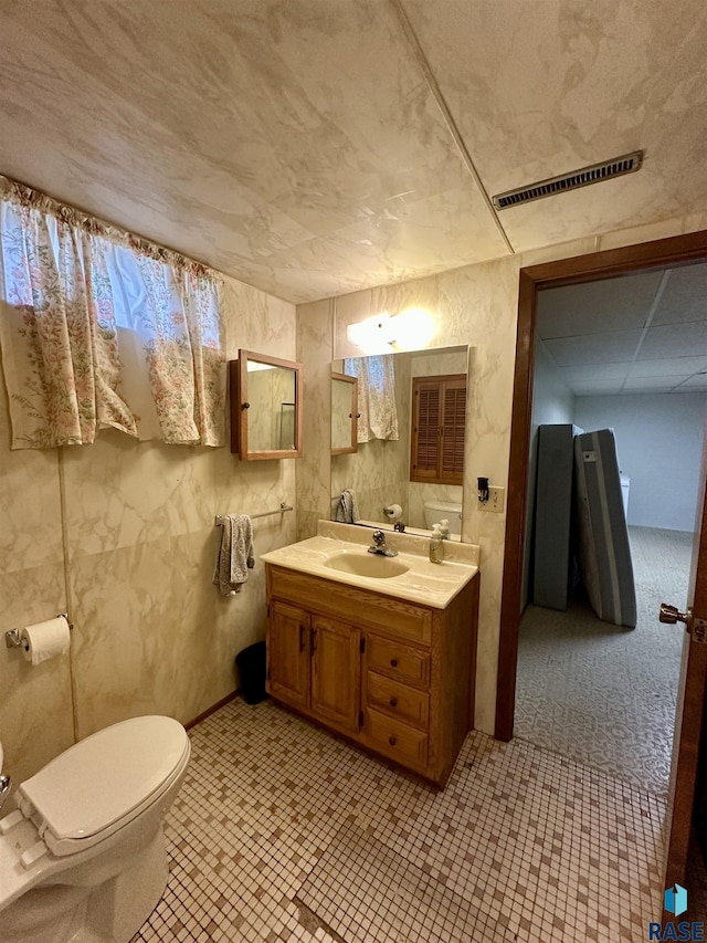 half bath featuring vanity, toilet, and visible vents
