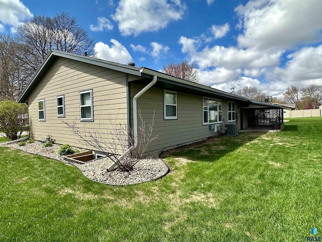 view of side of home with a lawn and central air condition unit