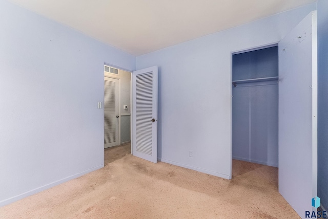 unfurnished bedroom with a closet, carpet, and baseboards
