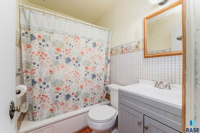 full bathroom with vanity, toilet, shower / bath combo with shower curtain, a wainscoted wall, and tile walls