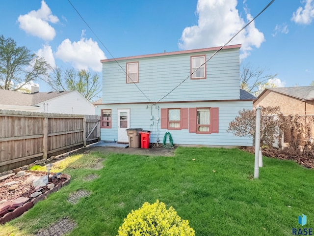 rear view of house with a yard and fence