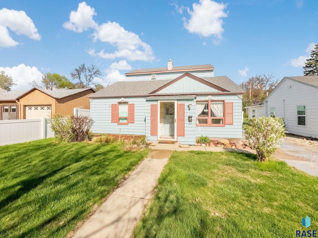 bungalow-style house featuring fence, a shingled roof, and a front yard