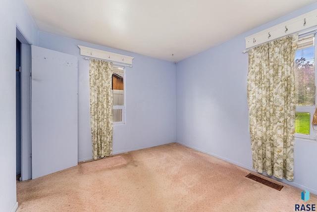empty room featuring carpet floors and visible vents