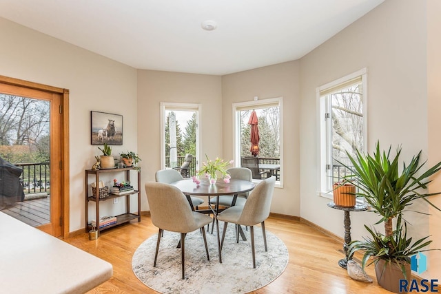 dining space with baseboards and light wood finished floors