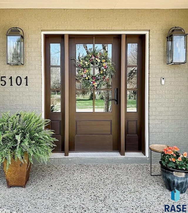 doorway to property featuring brick siding
