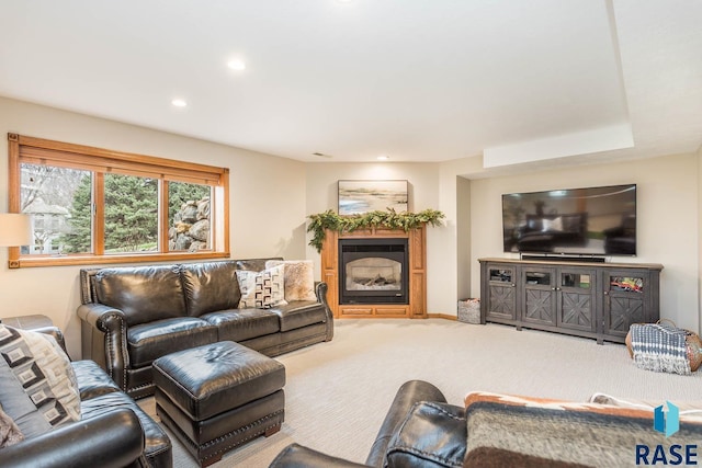 living area featuring a glass covered fireplace, carpet flooring, and recessed lighting