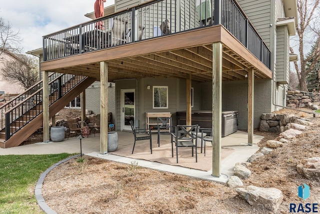 view of patio featuring stairs, a hot tub, and a wooden deck