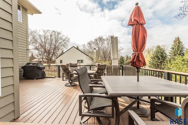 deck with grilling area and outdoor dining space