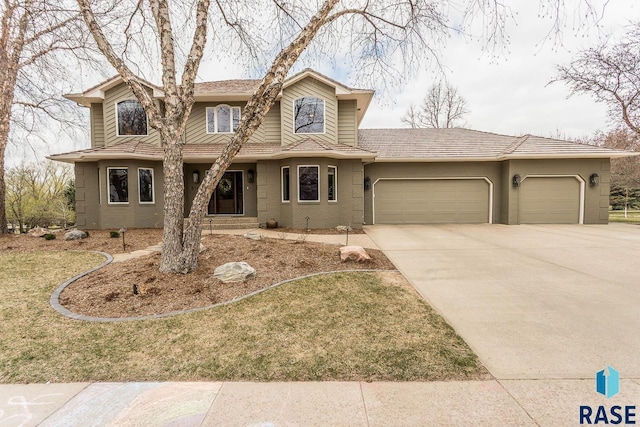 traditional-style house with a tiled roof, an attached garage, driveway, and stucco siding