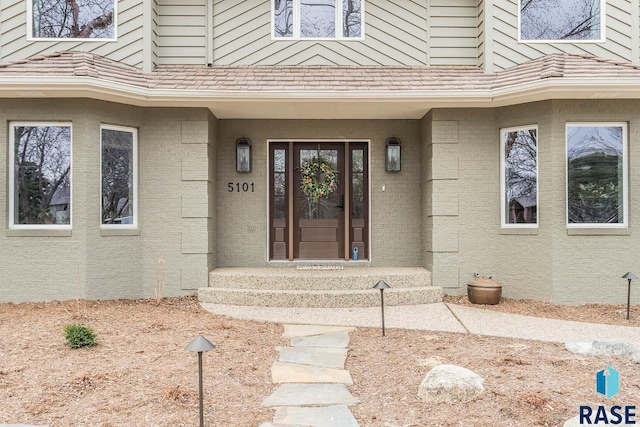 doorway to property with brick siding