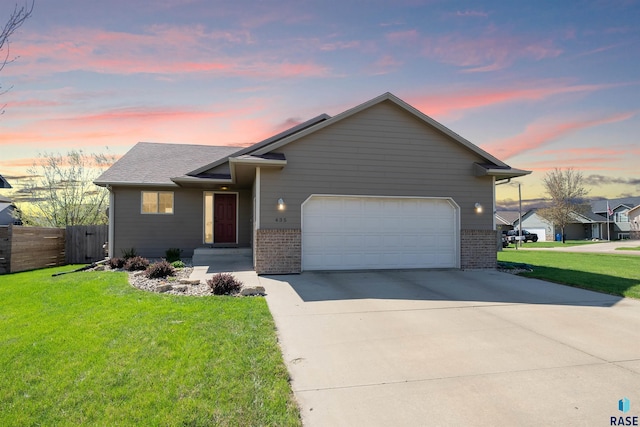 view of front of property featuring brick siding, an attached garage, driveway, and a front yard