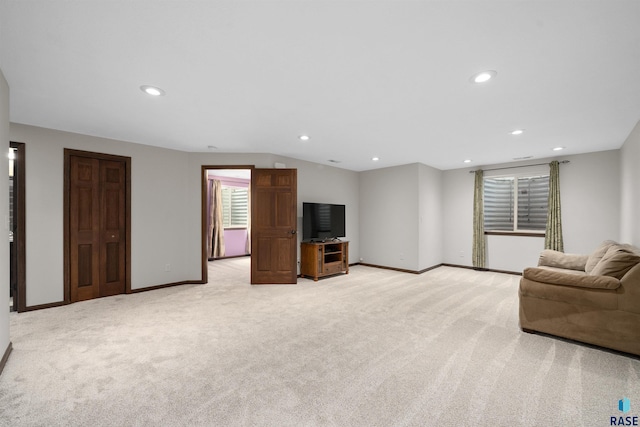 living room featuring recessed lighting, baseboards, light colored carpet, and lofted ceiling