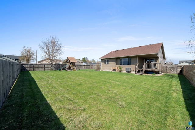 view of yard featuring a fenced backyard, a playground, and a wooden deck