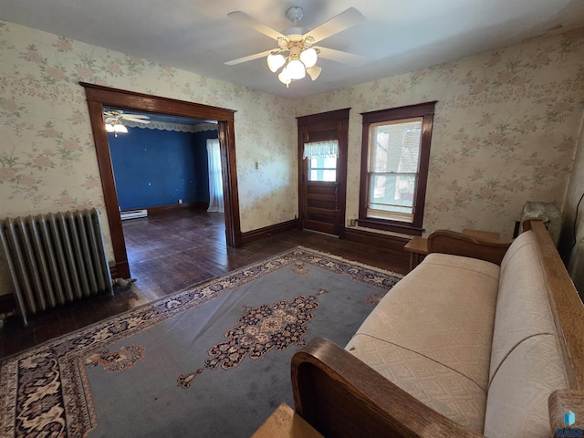 living room with ceiling fan, wallpapered walls, radiator heating unit, and wood finished floors