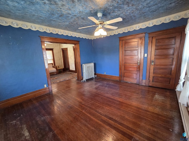 unfurnished room with radiator, baseboards, wood-type flooring, and ceiling fan