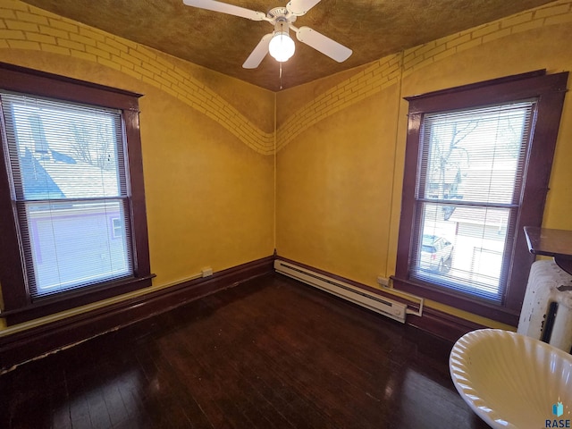 unfurnished room featuring a ceiling fan, baseboards, hardwood / wood-style floors, and a baseboard radiator