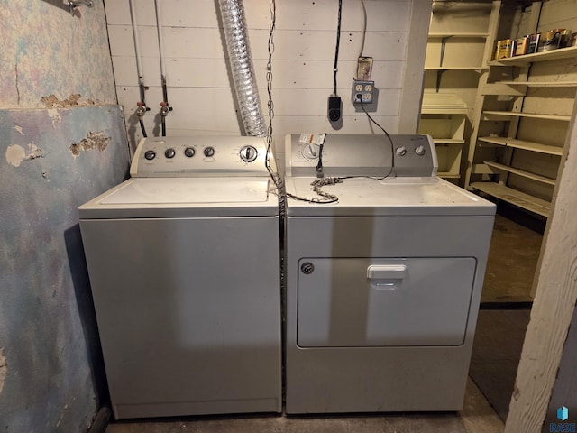 laundry room featuring washer and dryer and concrete block wall