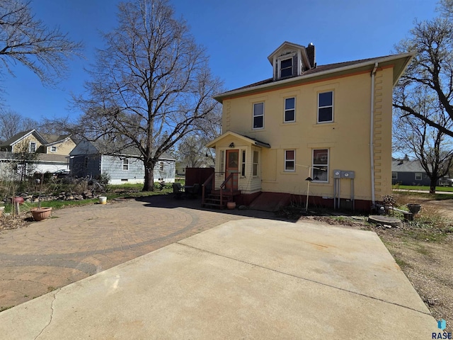 american foursquare style home with stucco siding and a chimney