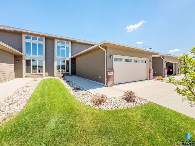 5714 S Woodlily Ave, Sioux Falls, SD 57108 - prairie-style house with concrete driveway, a front lawn, brick siding, and an attached garage