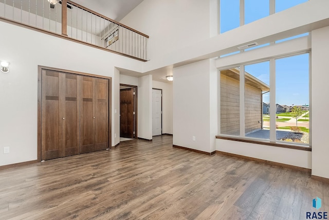5714 S Woodlily Ave, Sioux Falls, SD 57108 - unfurnished living room with wood finished floors, baseboards, and a towering ceiling