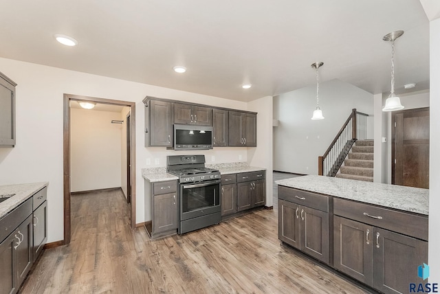 5714 S Woodlily Ave, Sioux Falls, SD 57108 - kitchen featuring light wood finished floors, dark brown cabinetry, appliances with stainless steel finishes, and decorative light fixtures