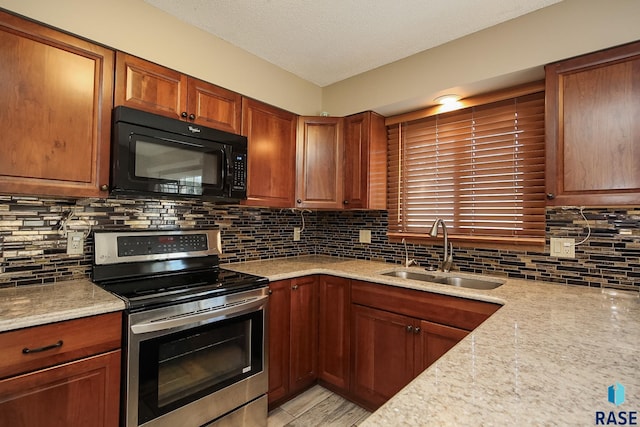 kitchen featuring light stone countertops, a sink, black microwave, electric stove, and backsplash