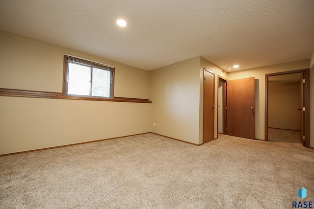 carpeted spare room featuring baseboards, recessed lighting, and a textured ceiling