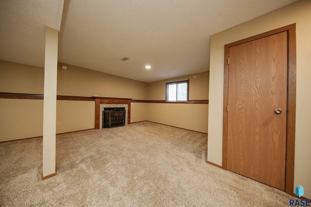 below grade area with carpet flooring and a tile fireplace