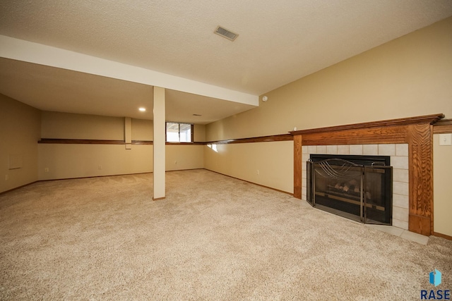 basement with baseboards, carpet flooring, a fireplace, and visible vents