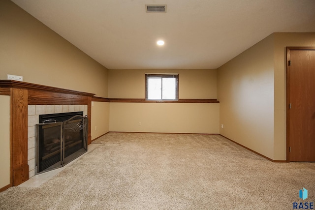 unfurnished living room with a fireplace, light carpet, baseboards, and visible vents