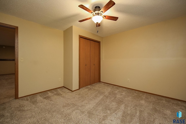 unfurnished bedroom with light colored carpet, a closet, ceiling fan, and baseboards