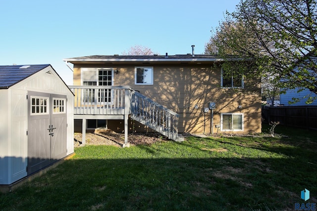 rear view of house featuring a yard, stairway, an outdoor structure, and a storage unit