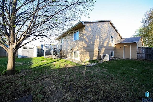 rear view of property featuring a storage shed, an outdoor structure, and stairs