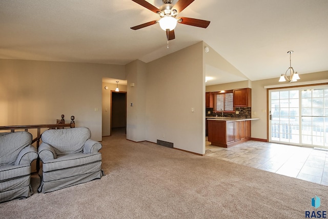 living area with ceiling fan, light carpet, lofted ceiling, and baseboards