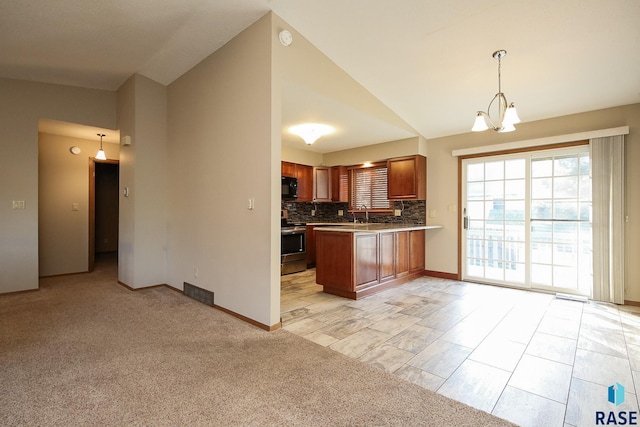 kitchen featuring vaulted ceiling, black microwave, stainless steel range with electric cooktop, and a healthy amount of sunlight