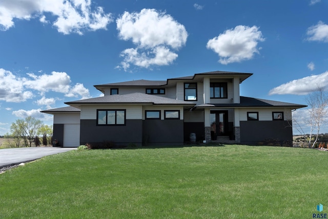 prairie-style house featuring driveway and a front yard