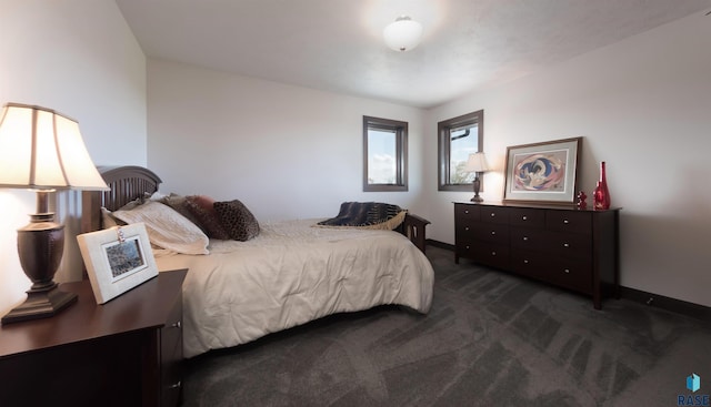 bedroom with baseboards and dark carpet