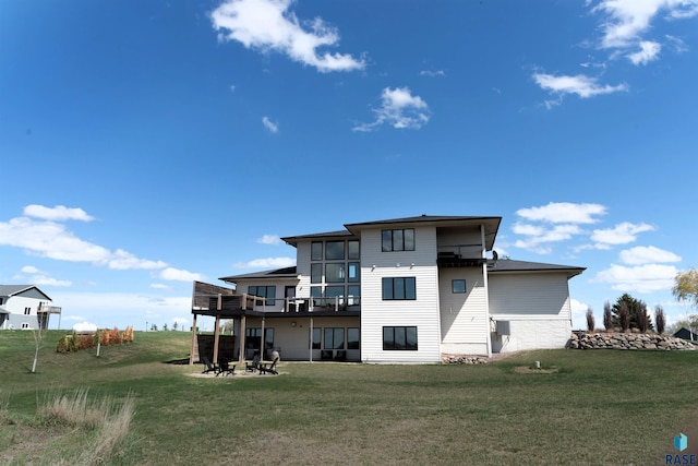 rear view of house featuring a wooden deck, a patio, and a lawn