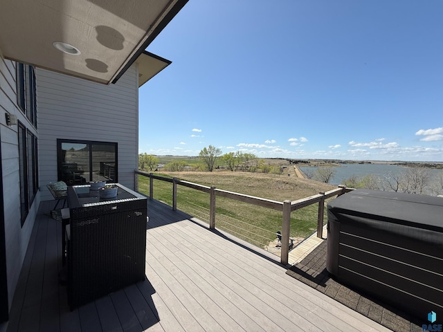 deck with a water view and a lawn