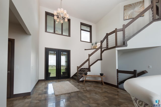 entrance foyer featuring stairway, an inviting chandelier, baseboards, and french doors
