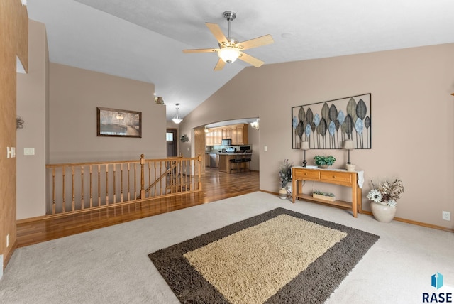 interior space featuring lofted ceiling, baseboards, a ceiling fan, and arched walkways