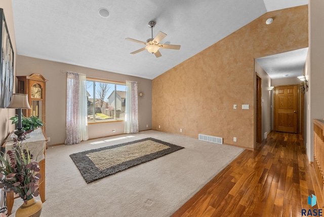 unfurnished living room featuring a ceiling fan, baseboards, wood-type flooring, visible vents, and high vaulted ceiling