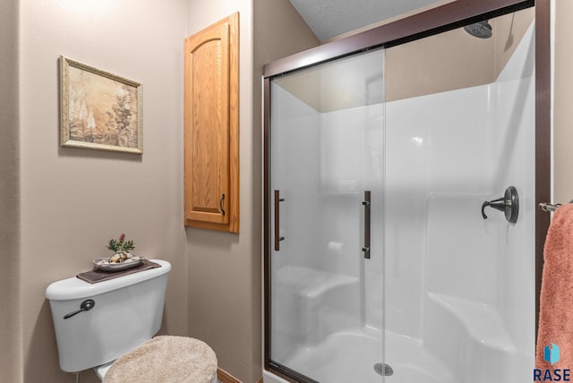 full bath featuring a stall shower, baseboards, and toilet