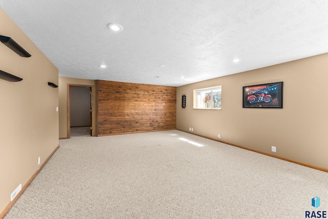 interior space with carpet floors, wood walls, visible vents, and recessed lighting