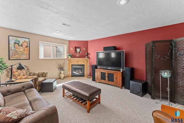 living room with a textured ceiling, visible vents, recessed lighting, carpet floors, and a glass covered fireplace