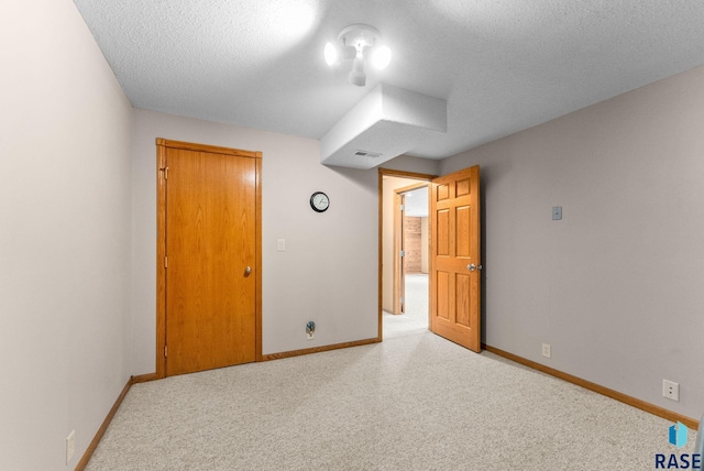 unfurnished bedroom featuring a textured ceiling, visible vents, and baseboards